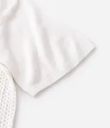 Remera de corte oversized confeccionada en tejido jacquard de color blanco con textura calada. Presenta mangas cortas, cuello redondo y un diseño gráfico deportivo con el número 23 en color negro en la parte frontal.