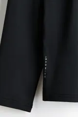 Remera deportiva de manga larga y cuello redondo, confeccionada en tejido funcional DryMove negro con aberturas cortas en el bajo.