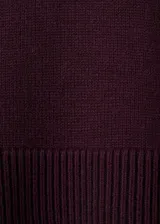 Jersey de punto de cuello alto, con diseño recto, aberturas laterales y manga larga con puños acanalados.