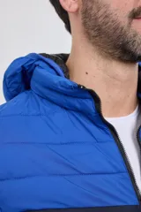 Campera capitoneada con capucha, con cambio de color tipo colorblock en verde militar y negro.