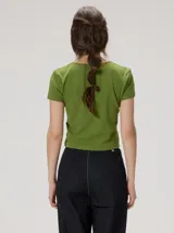 Remera negra de canalé ajustada al cuerpo, de manga corta y cuello redondo, con cierre frontal de botones metálicos.