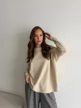 Remera oversize de viscosa color beige con textura acanalada, manga larga y detalle de etiqueta bordada en la manga.