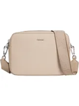 Cartera tipo bandolera o 'camera bag' de Calvin Klein, color beige claro, con exterior de piel sintética suave. Posee una correa ancha de jacquard con el logo repetido de la marca.
