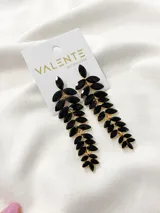Aros colgantes largos con forma de hojas, con engarce dorado y piedras facetadas negras.