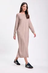 Vestido largo color beige de tejido de punto, con mangas largas y corte recto.