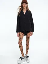 Chaqueta de corte recto y silueta cómoda, con cierre frontal de botones y bolsillos delanteros. Presenta un diseño estampado con efecto tie-dye en tonos negro y blanco.
