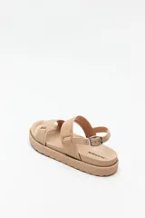 Sandalia estilo chunky color rosa metálico/cobre, con plataforma de goma texturizada. Posee dos tiras anchas ajustables con hebillas, una en el empeine y otra sobre los dedos, y una tira de tobillo con hebilla metálica.