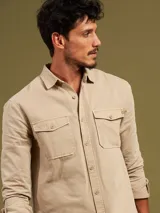 Camisa de manga larga color azul con dos bolsillos frontales con botón.