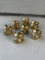 Anillo de diseño enlazado con textura irregular, realizado a mano en bronce. Presenta un diseño abierto que permite regular su tamaño con suavidad.