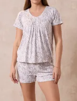 Conjunto de pijama marca René Rofé, compuesto por short y remera de tejido soft estampado. La remera tiene escote redondo con aplique de puntilla y detalle plisado. El short tiene cintura elastizada.