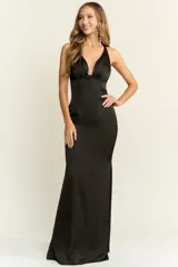 Vestido largo de corte sirena con escote profundo en V y espalda descubierta. Confeccionado en tela fluida con acabado satinado, presenta un diseño entallado que se ajusta al cuerpo.