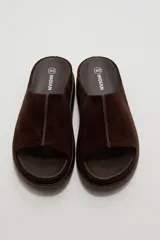 Sandalias de gamuza marrón, diseño abierto con tira ancha en el empeine y suela plana de goma.