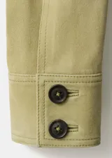 Chaqueta corta de piel de ante color verde, con diseño recto, cuello camisero, manga larga, dos bolsillos de parche en la parte delantera y cierre frontal con botones.