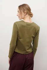 Cardigan negro de algodón con cuello redondo, cierre frontal de botones y costuras en contraste color ocre.