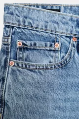 Jeans de tiro medio con cinco bolsillos, pernera recta y corte cropped. Cierre frontal con cremallera y botón.