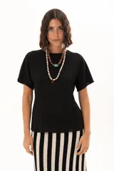 Blusa de textura arrugada en color negro, con cuello redondo y mangas cortas de corte holgado.