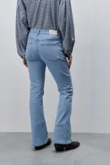 Jean flare de tiro medio, color celeste, con calce al cuerpo hasta la rodilla y pierna levemente acampanada.