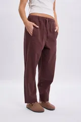 Pantalón casual marrón de corte holgado y relajado, con cintura elástica y cordón ajustable.