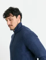 Sweater de punto inglés color verde, con cuello alto y cierre frontal parcial metálico. Diseño de manga larga con puños y ruedo acanalados.