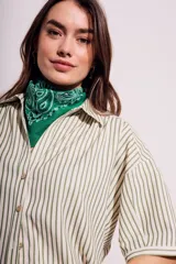 Camisa oversize a rayas verticales color verde y blanco, con mangas cortas y botones nacarados.