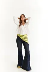 Blusa blanca de algodón con diseño de escote en V, mangas largas abullonadas y detalle de frunces en el frente y la espalda.