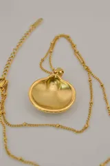 Collar dorado con cadena de eslabones y dije de caracol marino.