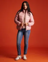 Campera puffer reversible color beige, marca Michael Kors. Un lado es liso y el otro estampado. Tiene cierre metálico central, bolsillos delanteros y bolsa autoportante.