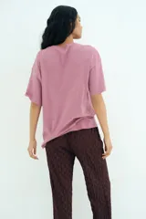 Remera de corte oversized en punto de algodón, con cuello redondo acanalado y mangas cortas de hombros caídos. Presenta un estampado frontal artístico con la inscripción Matisse y motivos abstractos.