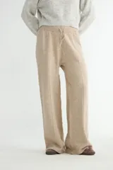 Pantalón tejido de corte recto y tiro alto, color beige, con cintura elástica ajustable mediante cordón y costura central vertical en cada pierna.