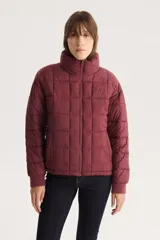 Campera puffer acolchada color borgoña con cuello alto y cierre frontal.
