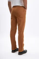 Pantalon de corte recto confeccionado en pana color tostado, con diseño clásico de cinco bolsillos y cierre frontal con botón y cremallera.