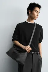 Bolso tipo bandolera de piel con acabado grabado, diseño rectangular con solapa frontal y cierre magnético. Cuenta con un asa de hombro ajustable y compartimento interior con cierre de cremallera.