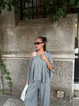 Blusa de lanilla gris con diseño asimétrico de un solo hombro y corte holgado tipo capa.