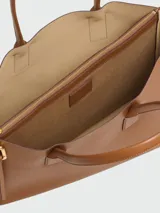 Cartera tipo tote bag Marc Jacobs The Puffy J Marc Work Tote, color negro con herrajes dorados y logotipo de la marca impreso en el frente.
