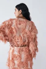 Campera bomber color naranja confeccionada en organza de seda con hilos de lurex y detalles en cuero.