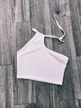 Top blanco irregular con un solo bretel y espalda descubierta.