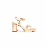 Sandalia de cuero metalizado dorado claro, con taco alto ancho, plataforma delantera, tira frontal y pulsera regulable al tobillo con hebilla. Punta cuadrada abierta.