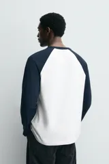 Camiseta de corte relajado con cuello redondo y mangas largas tipo raglán en contraste de color.