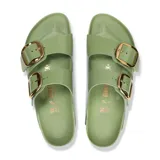Sandalia Birkenstock modelo Arizona con dos correas anchas de cuero con acabado brillante en color verde. Presenta hebillas grandes metálicas doradas y plantilla anatómica de corcho con suela de goma negra.