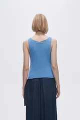 Musculosa verde melange de tejido de punto con tres aberturas circulares en el frente.