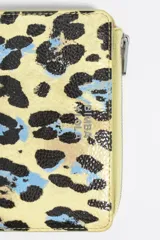 Billetera mediana con exterior rígido y textura brillante, con estampado de leopardo en tonos azul celeste, negro y naranja. Presenta cierre de cremallera y logo metálico de Bimba y Lola en el frente.