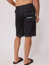 Short de baño negro con cordón ajustable en la cintura, bolsillos laterales y logo de la marca Rusty estampado en la pierna izquierda.