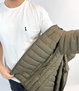 Campera puffer verde oliva de nylon con capucha desmontable y bolsillos laterales.