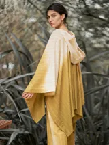 Poncho con capucha a rayas horizontales verdes y blancas, con falda a rayas verticales rosas y marrones.