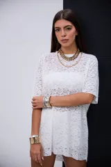 Remerón de encaje blanco con cuello redondo y mangas cortas.