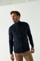 Campera tejida azul marino con cierre frontal, cuello alto y mangas largas.