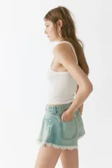 Short de cinco bolsillos en denim de algodón rígido, de tiro alto con cierre y botón, corte holgado con bajo deshilachado.