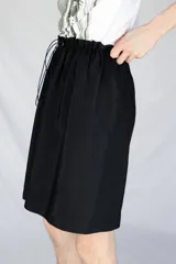 Bermuda holgada negra con cintura elastizada y hebillas de ajuste.