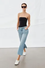 Jeans de tiro medio con corte flare y largo cropped. Presentan diseño de cinco bolsillos, cierre frontal con cremallera y botón, raya planchada en el delantero y bajo desflecado con acabado evasé.