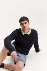 Sweater de punto texturizado color azul marino, de manga larga, con cuello polo en color beige contrastante.